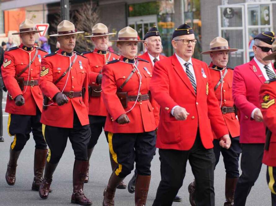 RCMP Depot Division officers in red serge ceremonial uniforms marching in formation, representing Canada's national police training academy established in 1885