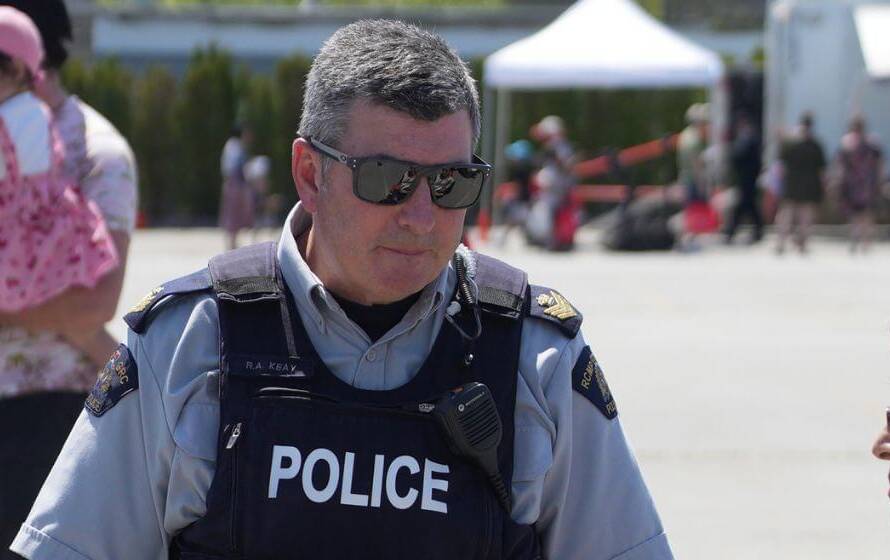 RCMP police officer speaking with a civilian at a community event, representing training and preparation for recruits attending Depot.