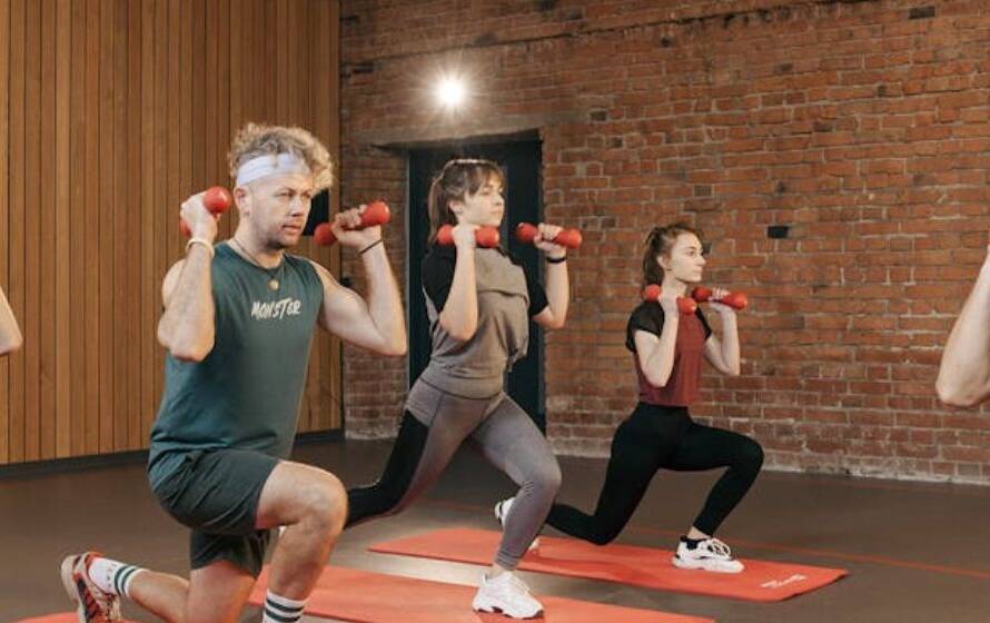 Group performing lunges with dumbbells during structured RCMP Level 1 fitness training program