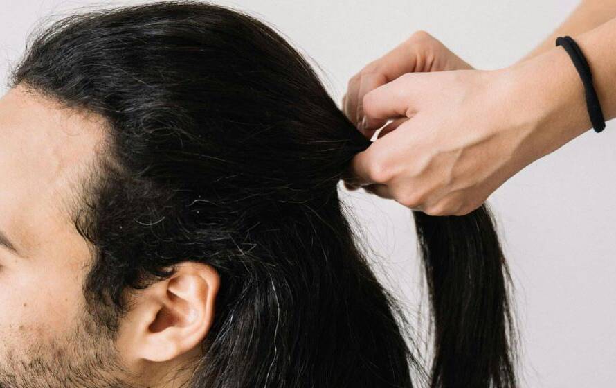 Applicant tying long hair back to meet RCMP appearance standards
