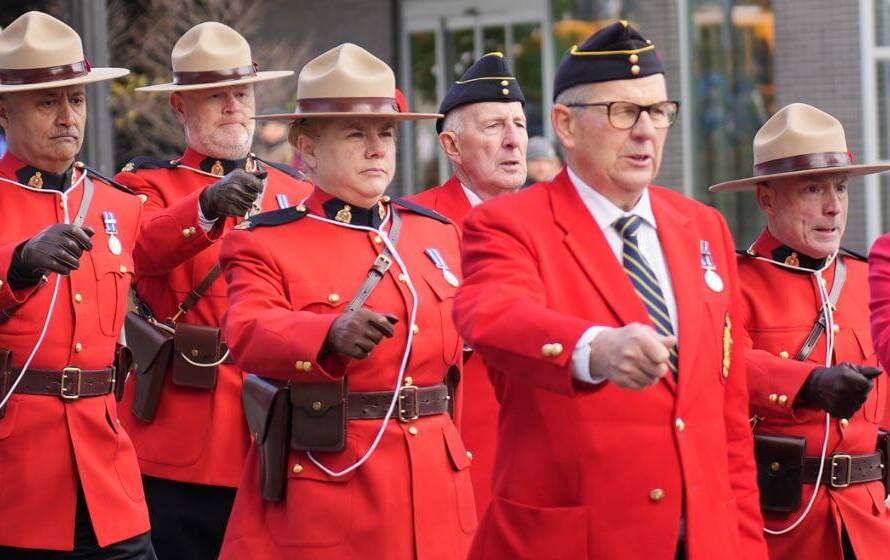 RCMP officers in red serge uniforms during ceremonial march in Canada
