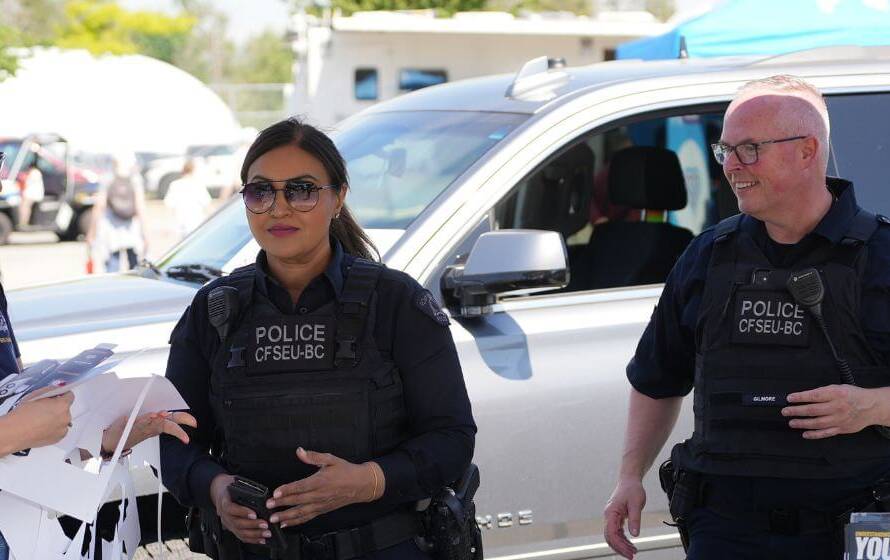 RCMP officers speaking with the public during a community event in Canada representing the physical fitness and recruitment standards required for the RCMP PARE fitness test.