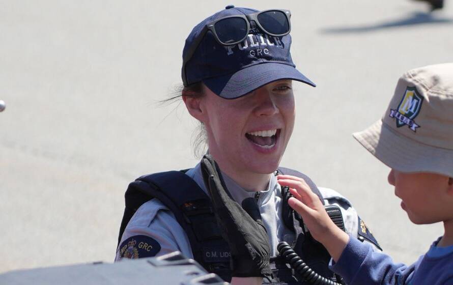 RCMP officer speaking with a young child during a community outreach event, illustrating public engagement and the RCMP recruitment process discussed by applicants on Reddit.